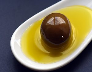 Olive in weißer Schale gefüllt mit Olivenöl